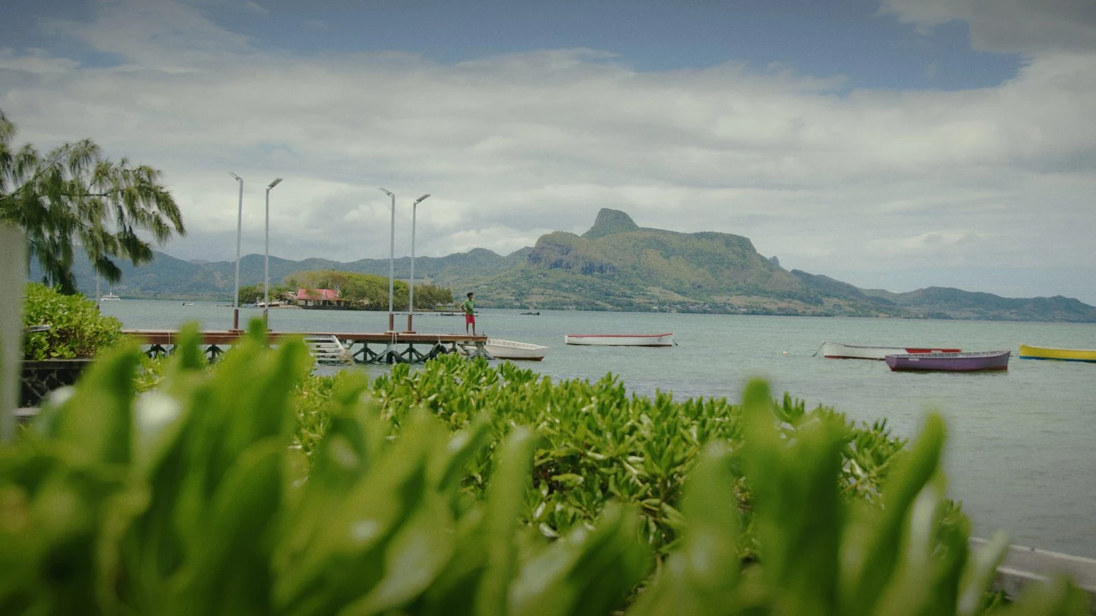 Boats beside a jetty and the Mauritian coastline in a Groundwork film still